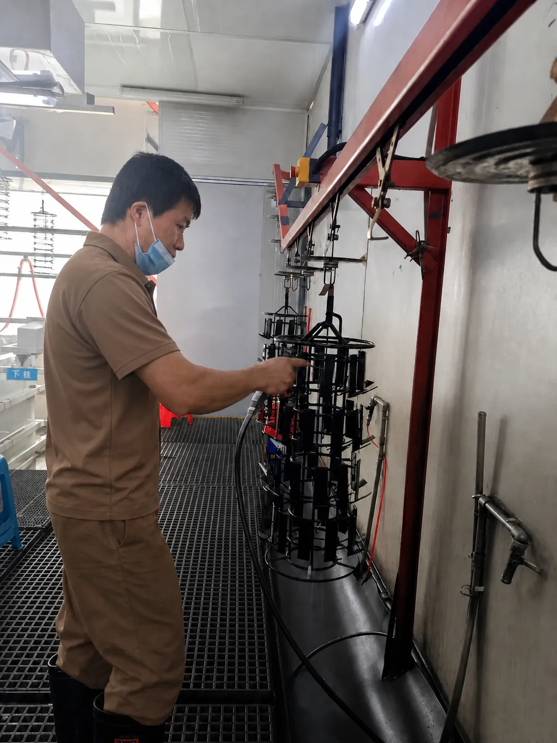 Technician checking plated components on a rack